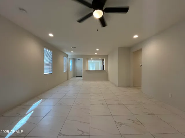 a view of hallway with a window and chandelier fan
