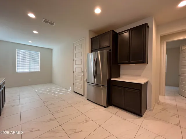 a kitchen with granite countertop a refrigerator and a stove top oven