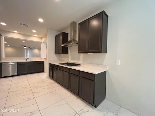 a large kitchen with stainless steel appliances a sink and a microwave