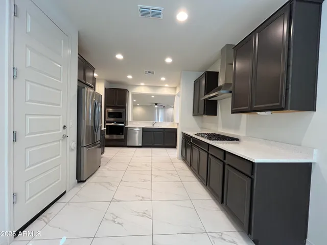 a large kitchen with a large counter top stainless steel appliances and cabinets