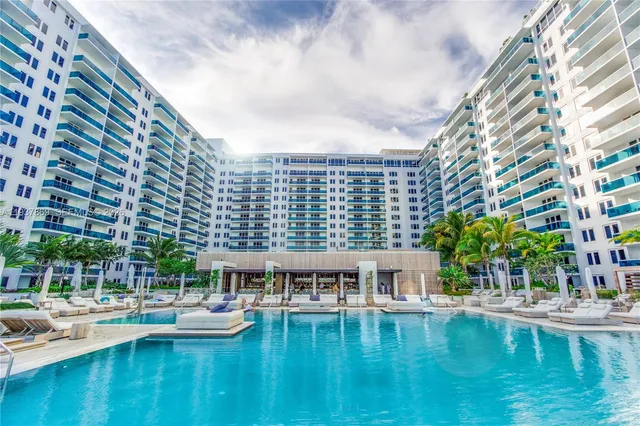 a view of pool with outdoor seating and city view