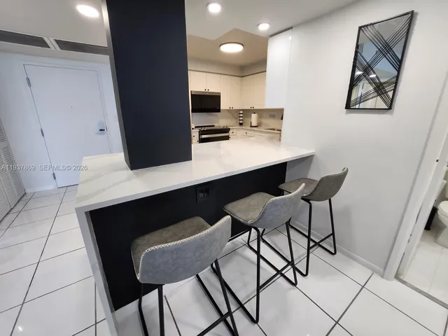 a room with a table chairs and a refrigerator