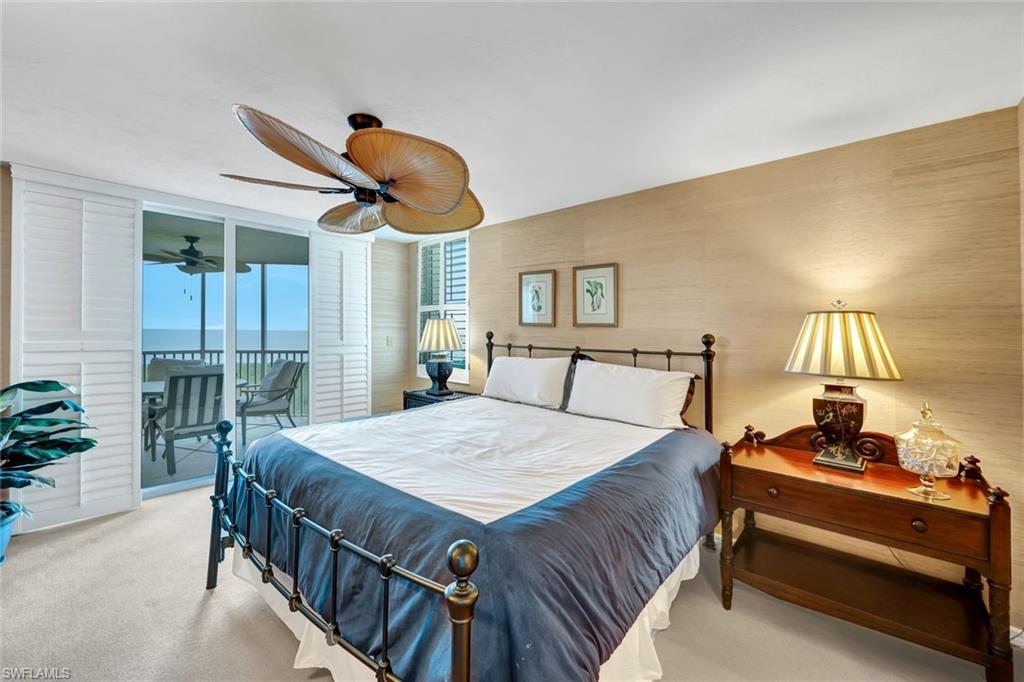 6573 Marissa Loop, Unit 2003 Naples, FL 34108 - Photo 15 of 41 a bed room with a bed and a chandelier