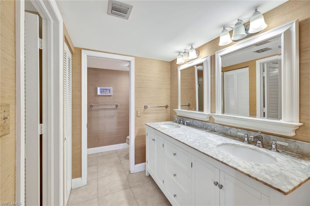 6573 Marissa Loop, Unit 2003 Naples, FL 34108 - Photo 16 of 41 a bathroom with a granite countertop sink and a mirror