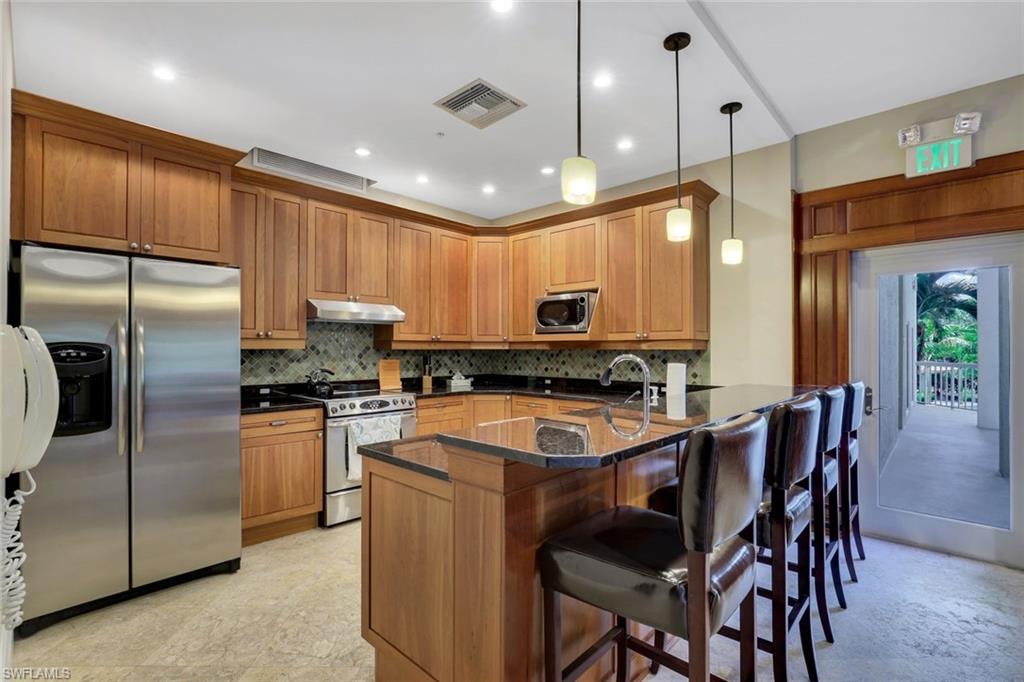 6573 Marissa Loop, Unit 2003 Naples, FL 34108 - Photo 30 of 41 a kitchen with stainless steel appliances granite countertop a sink a stove a refrigerator and island