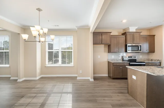 a kitchen with kitchen island granite countertop a sink cabinets and stainless steel appliances