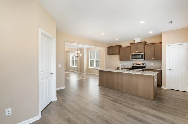 a kitchen with stainless steel appliances granite countertop a refrigerator and a stove top oven