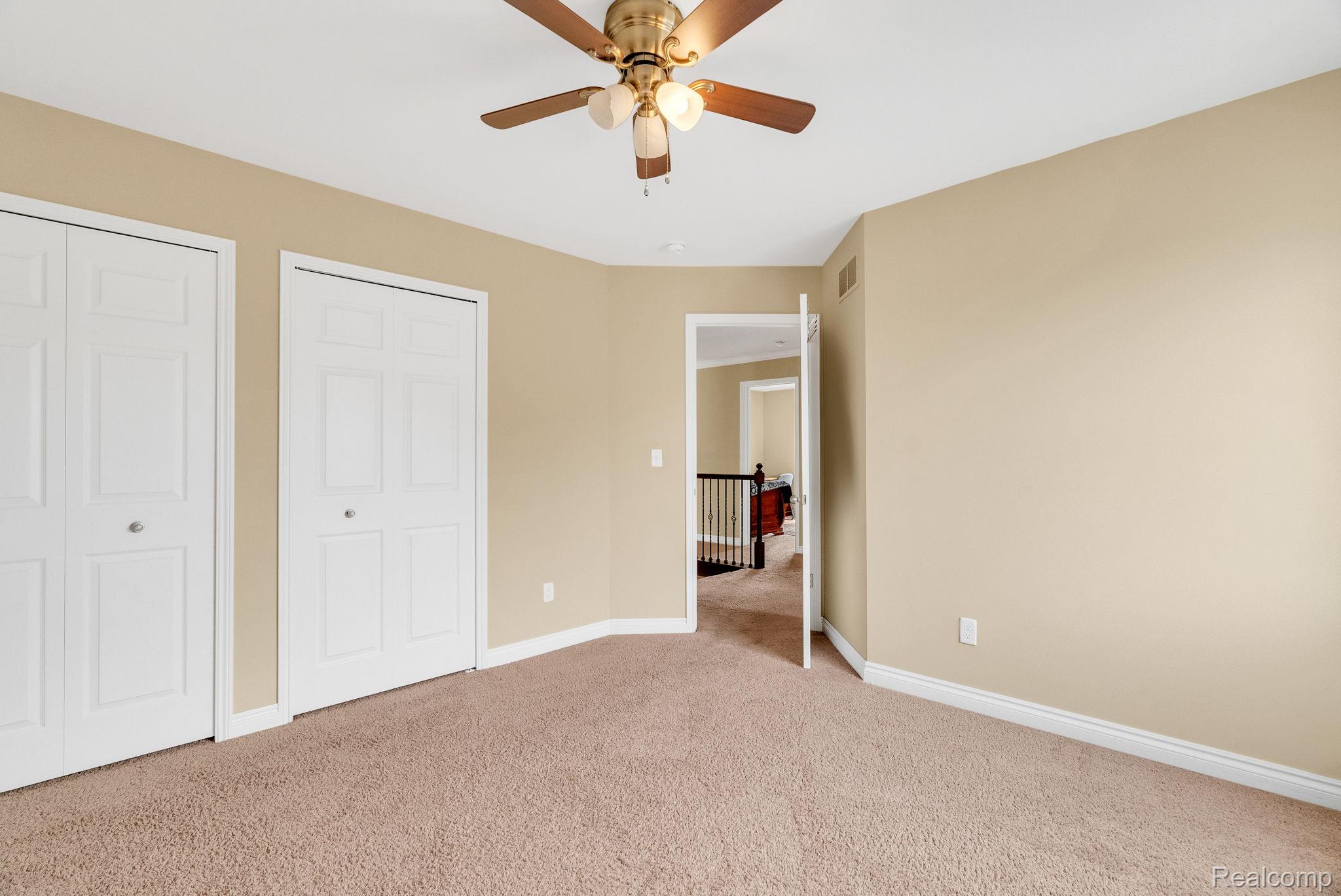 4122 Hawks Nest Road Utica, MI 48317 - Photo 51 of 74 Unfurnished bedroom featuring multiple closets, light carpet, and ceiling fan