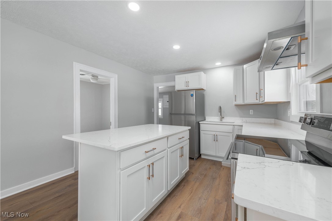 218 Roxboro Road Vermilion, OH 44089 - Photo 14 of 50 Kitchen with electric range, freestanding refrigerator, dark wood finished floors, light stone countertops, and a center island
