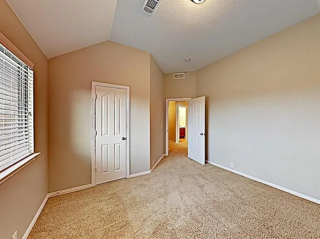 an empty room with windows and closet
