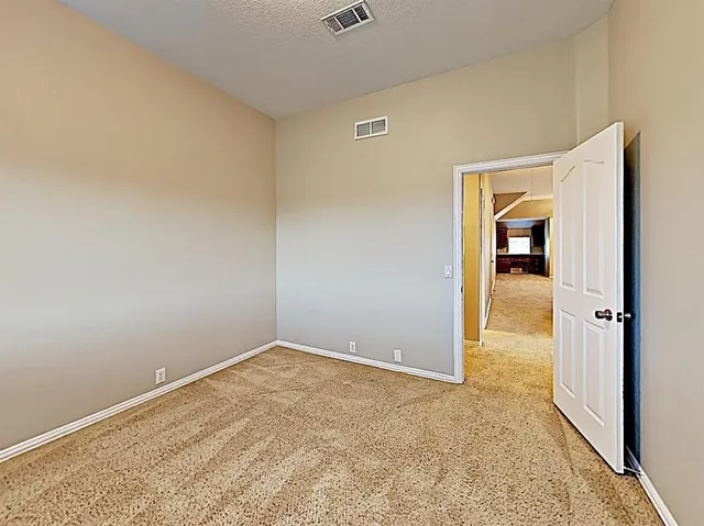 an empty room with an entryway and wooden floor