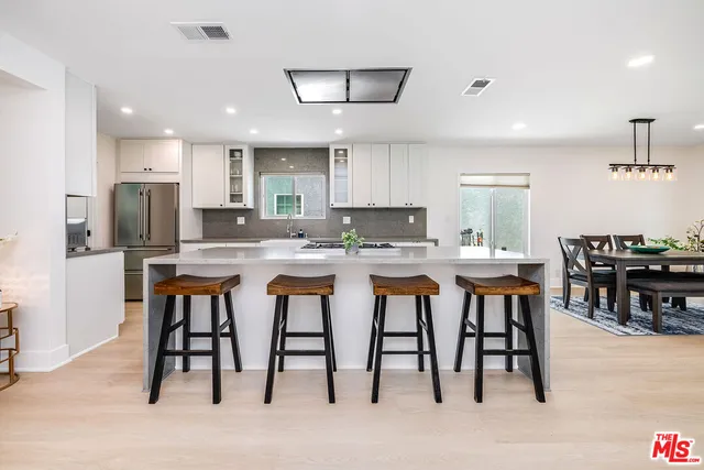 a kitchen with kitchen island granite countertop a table and chairs in it
