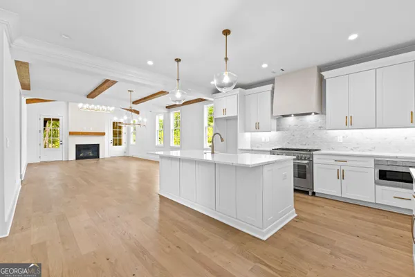 a view of a kitchen with granite countertop a sink stainless steel appliances and cabinets