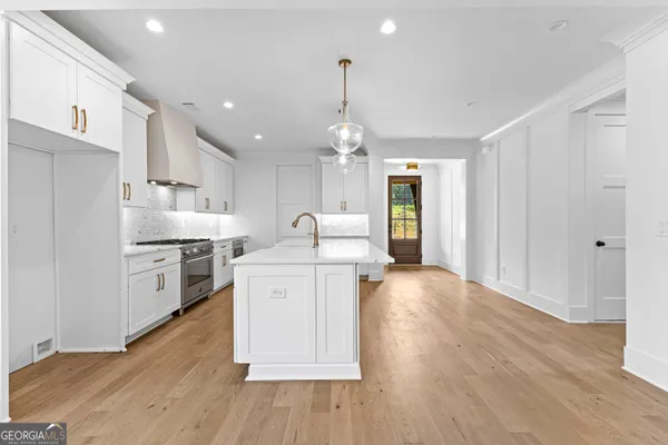 a large white kitchen with sink stove and refrigerator