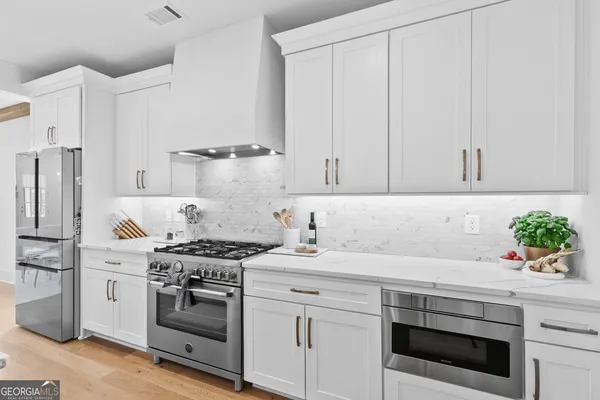 a kitchen with a stove and white cabinets