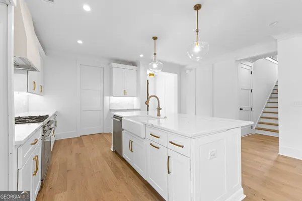 a kitchen with stainless steel appliances a sink a stove top oven a counter space and cabinets