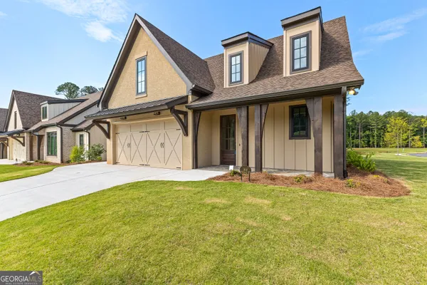 a front view of a house with a garden and garage