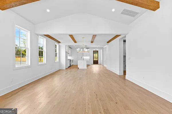 a view of a hallway with wooden floor and windows
