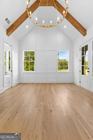 a view of a hallway with bathroom and wooden floor