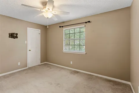 an empty room with windows and fan