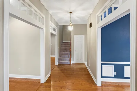 a view of a hallway with wooden floor and staircase