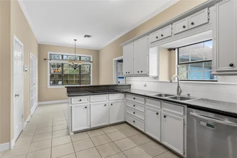 a kitchen with granite countertop white cabinets white appliances with a sink and dishwasher
