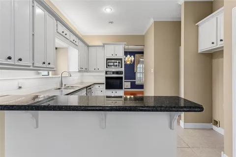 a kitchen with stainless steel appliances granite countertop a sink stove and cabinets