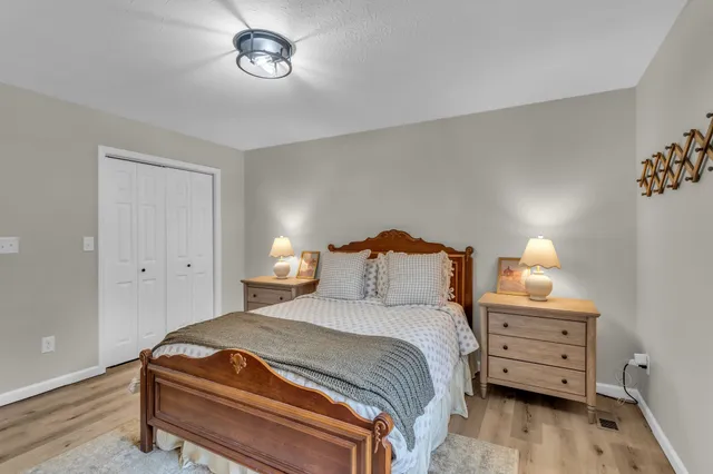a bedroom with a bed and a lamp on dresser