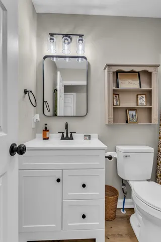 a bathroom with a toilet sink and mirror