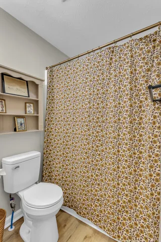 a bathroom with a toilet and a shower curtain
