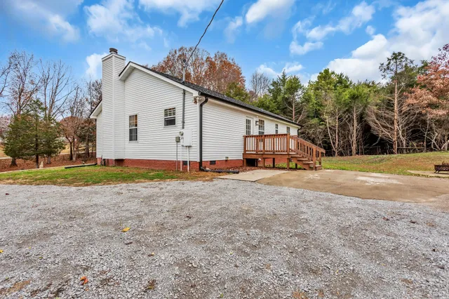 a view of a house with backyard and trees