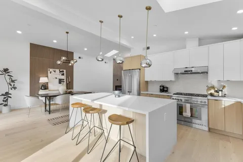 a kitchen with kitchen island a stove a table and chairs in it