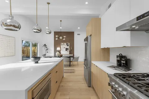 a kitchen with stainless steel appliances a stove a sink and a refrigerator