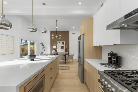 a large kitchen with stainless steel appliances granite countertop a lot of counter space and a sink