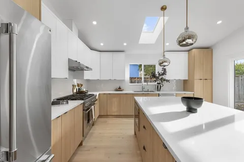 a kitchen with stainless steel appliances granite countertop a sink a stove and a refrigerator