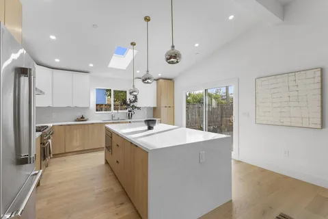 a large kitchen with kitchen island a sink stainless steel appliances and cabinets