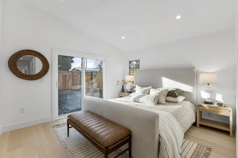 a bedroom with a bed and a lamp next to a window