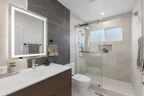a bathroom with a sink a toilet and shower
