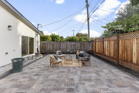 a view of patio with a table and chairs and a barbeque