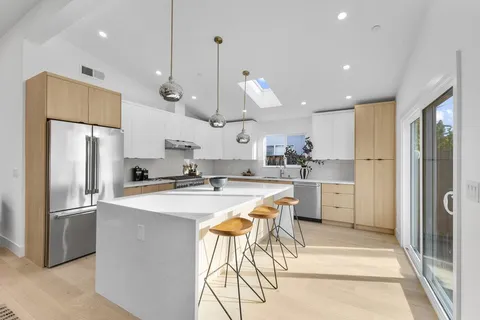 a kitchen with stainless steel appliances kitchen island a refrigerator and a stove top oven