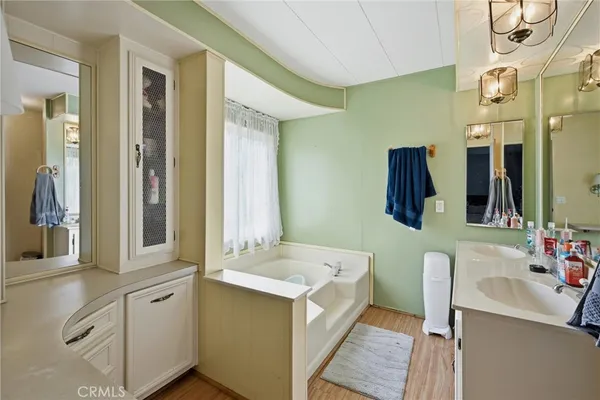 a bathroom with a tub sink and mirror