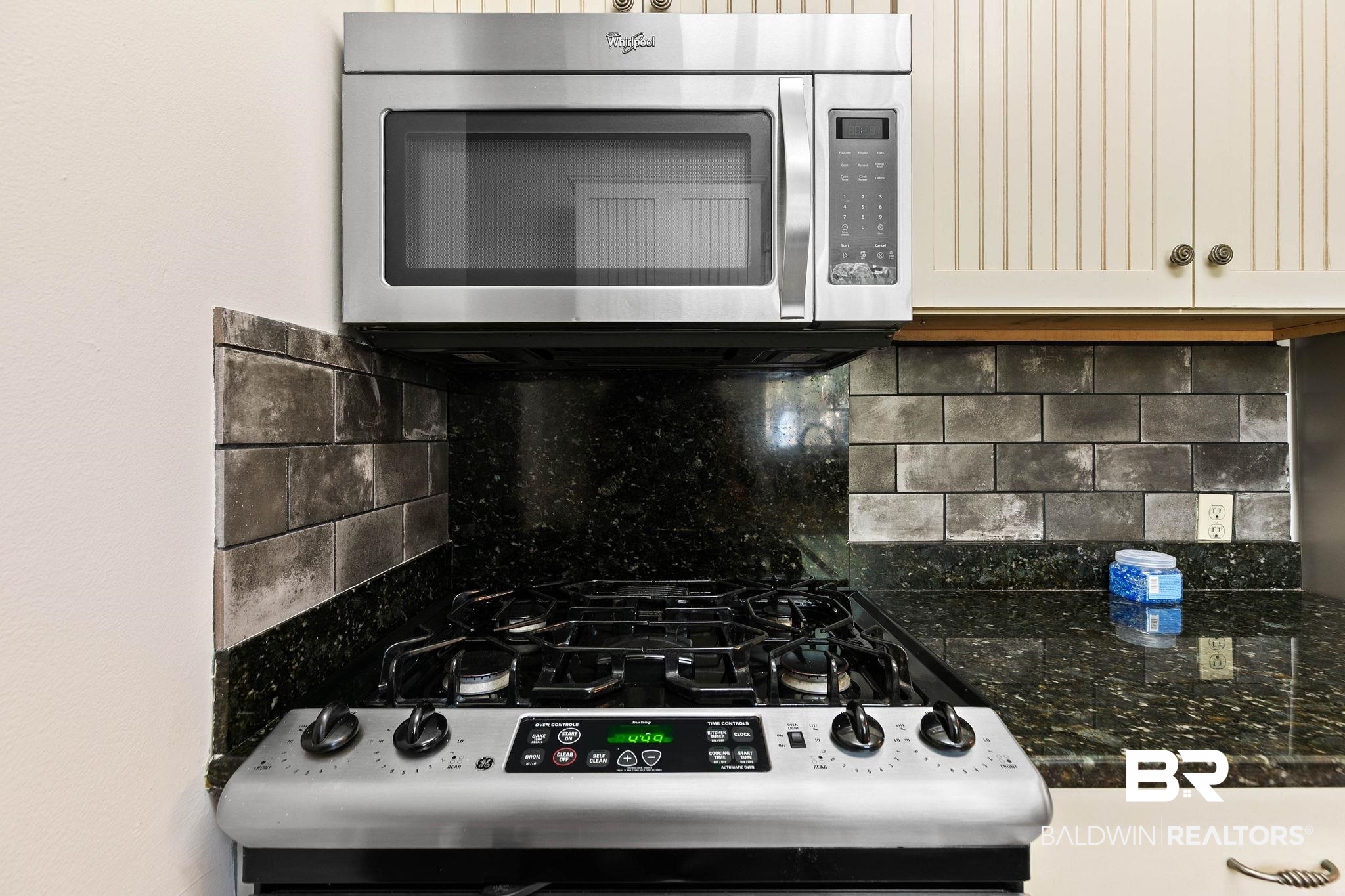 214 Upham Street, Unit 8D Mobile, AL 36607 - Photo 12 of 36 Kitchen with stainless steel appliances, decorative backsplash, and dark stone countertops
