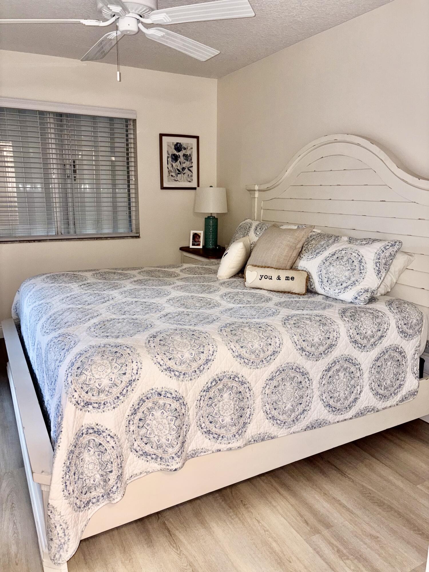 242 Village Boulevard, Unit 2304 Tequesta, FL 33469 - Photo 18 of 34 a bedroom with a bed and wooden floor