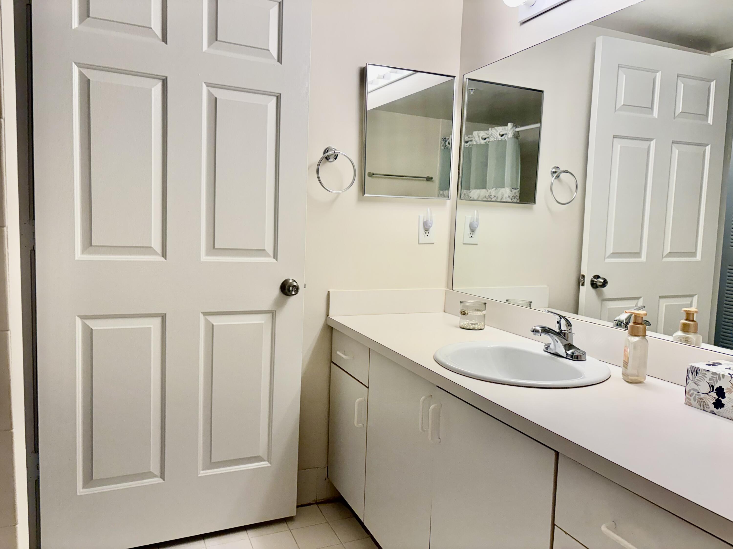 242 Village Boulevard, Unit 2304 Tequesta, FL 33469 - Photo 23 of 34 a bathroom with a sink and a mirror