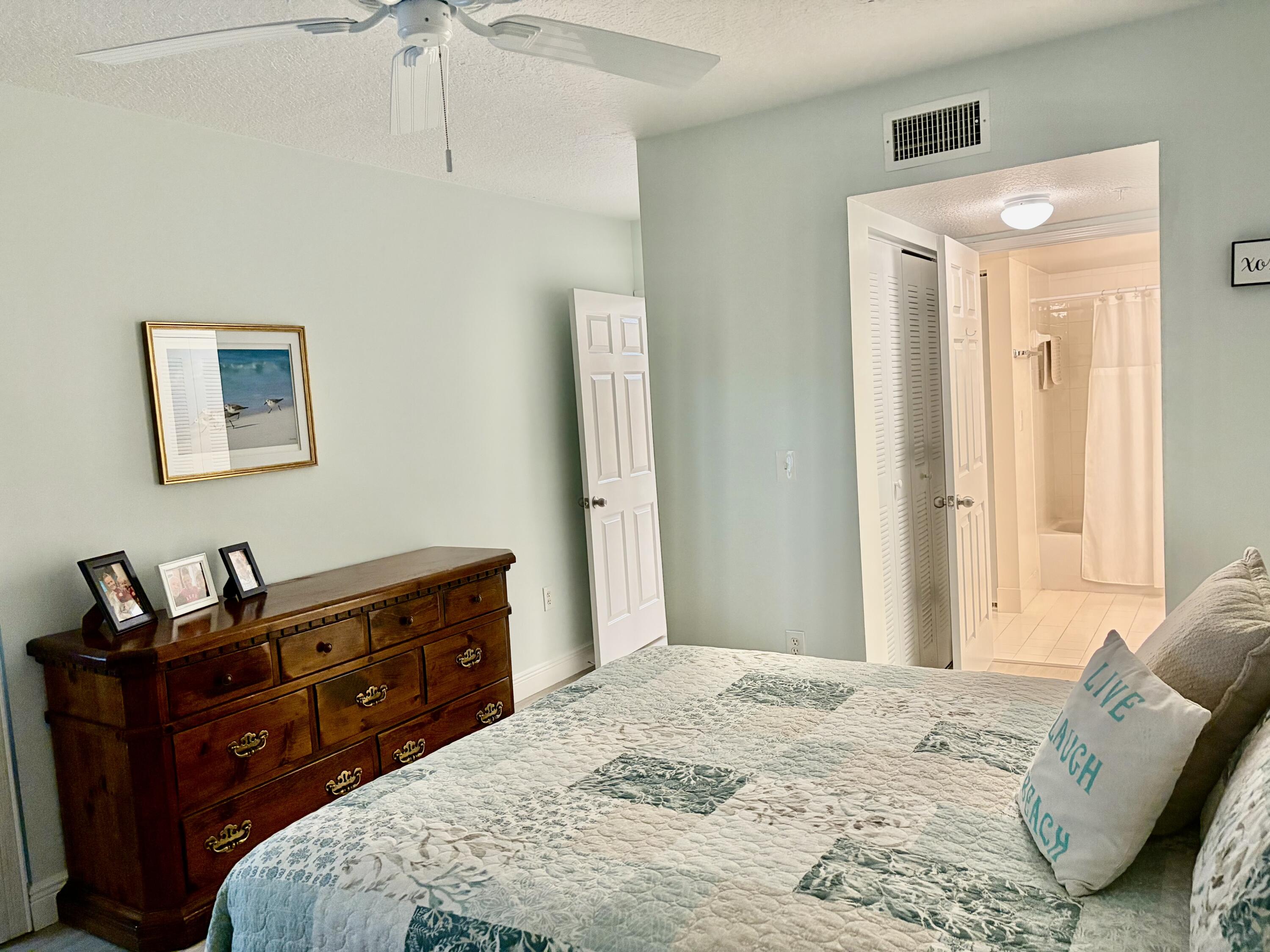 242 Village Boulevard, Unit 2304 Tequesta, FL 33469 - Photo 26 of 34 a bedroom with a bed and wooden floor