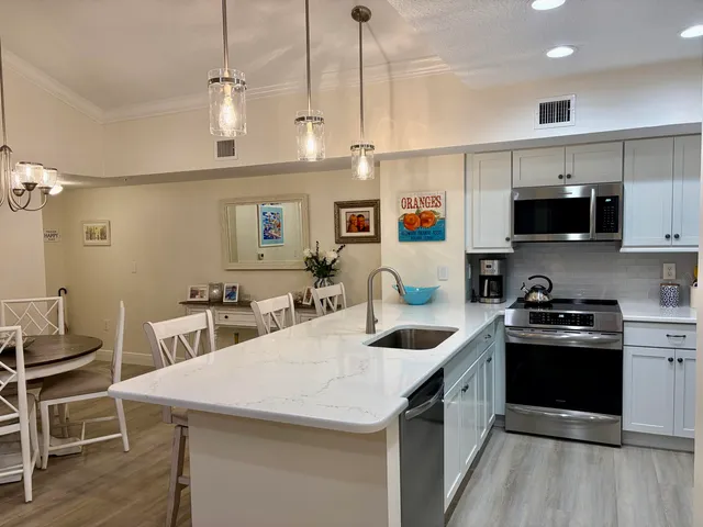 a kitchen with stainless steel appliances granite countertop a sink a stove and a refrigerator