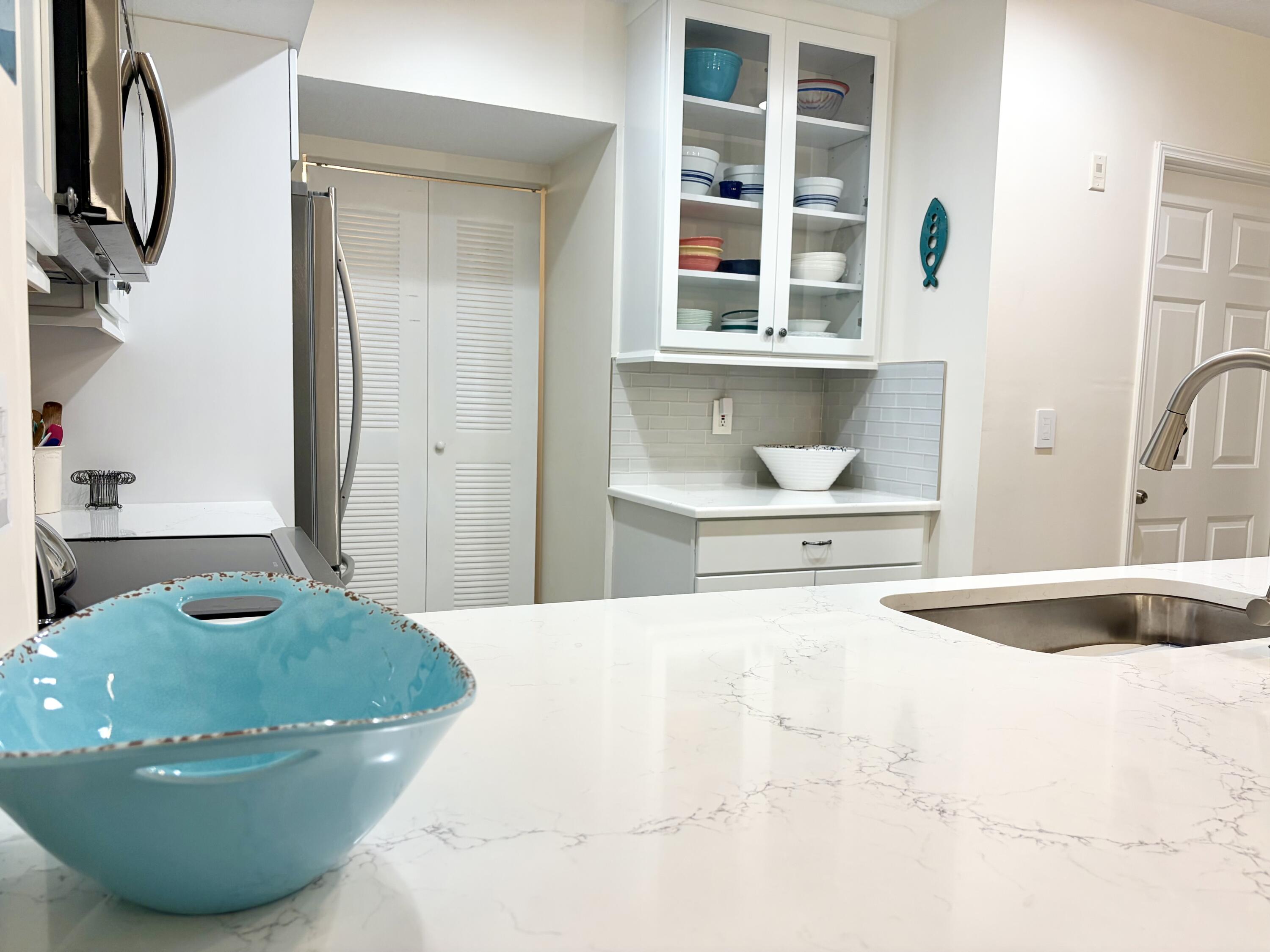 242 Village Boulevard, Unit 2304 Tequesta, FL 33469 - Photo 4 of 34 a view of a kitchen area with wooden floor