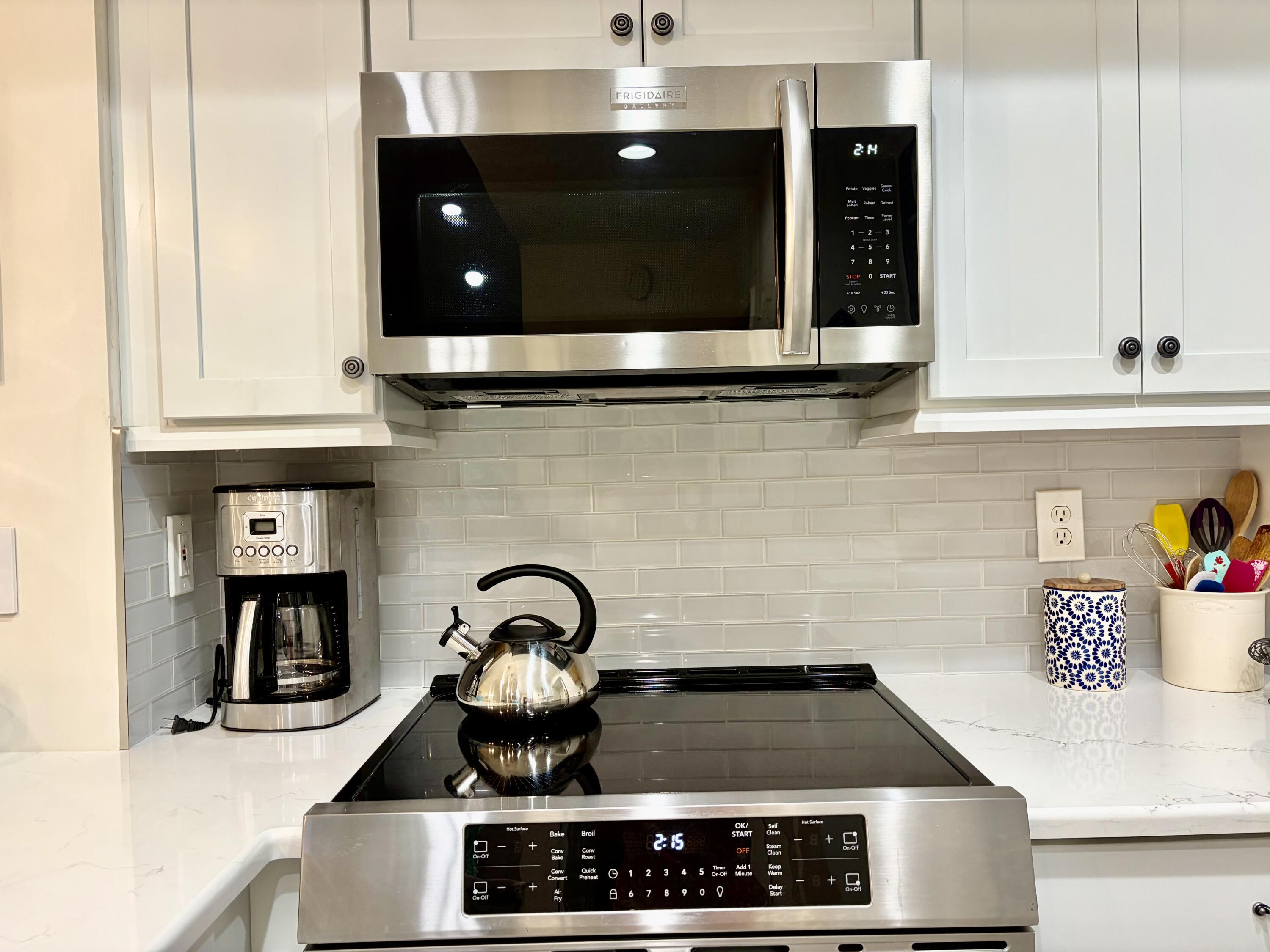 242 Village Boulevard, Unit 2304 Tequesta, FL 33469 - Photo 5 of 34 a kitchen with a stove and a microwave