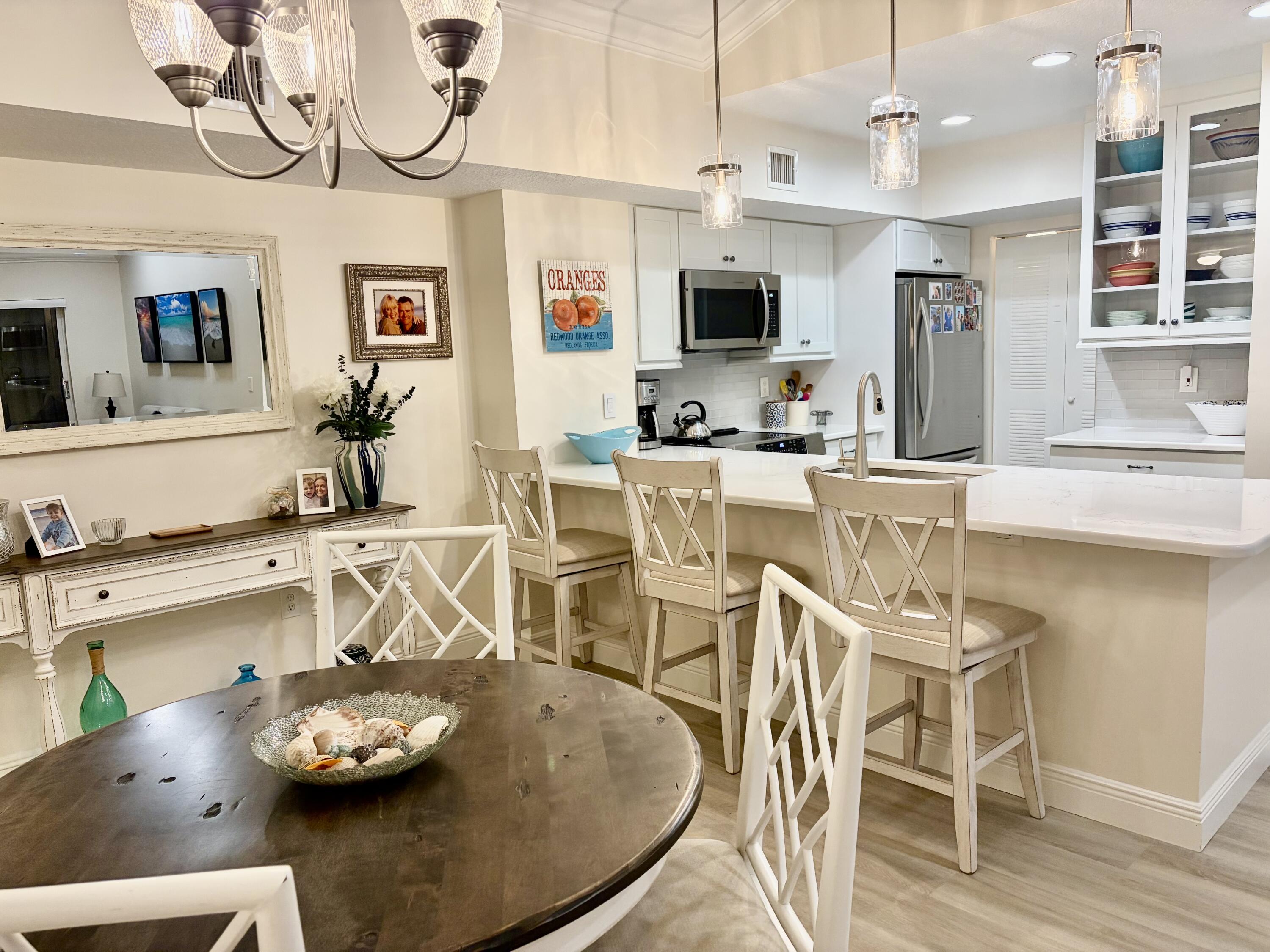 242 Village Boulevard, Unit 2304 Tequesta, FL 33469 - Photo 7 of 34 a kitchen with stainless steel appliances kitchen island granite countertop a sink and cabinets