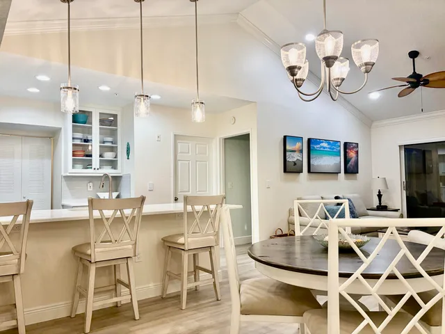 a view of a dining room with furniture a chandelier and wooden floor